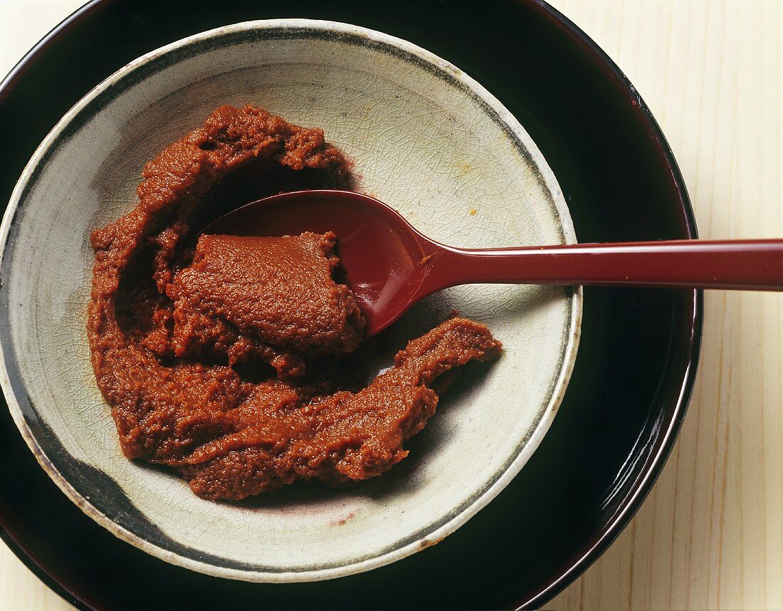 Red curry paste in a small bowl with spoon