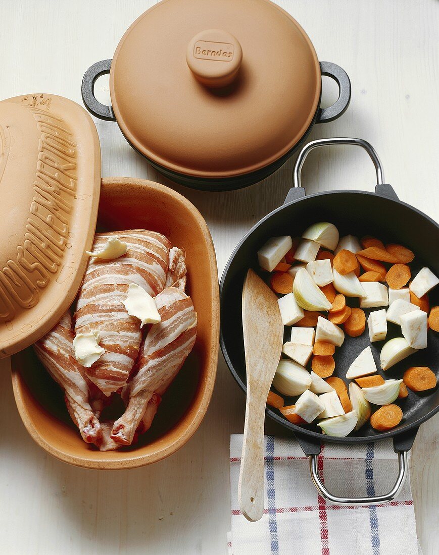 Bacon-wrapped chicken in a clay pot, vegetables in pan