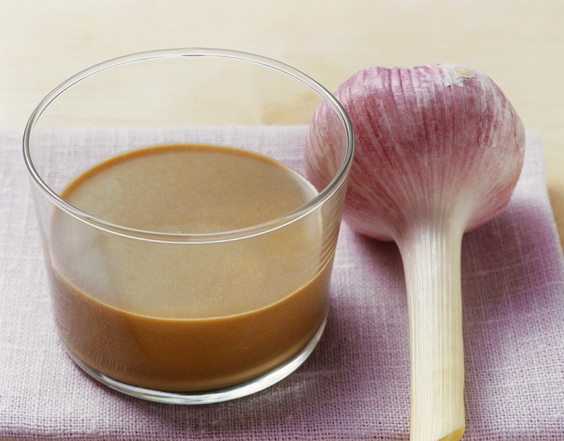 Balsamic vinegar dressing in a glass, garlic bulb