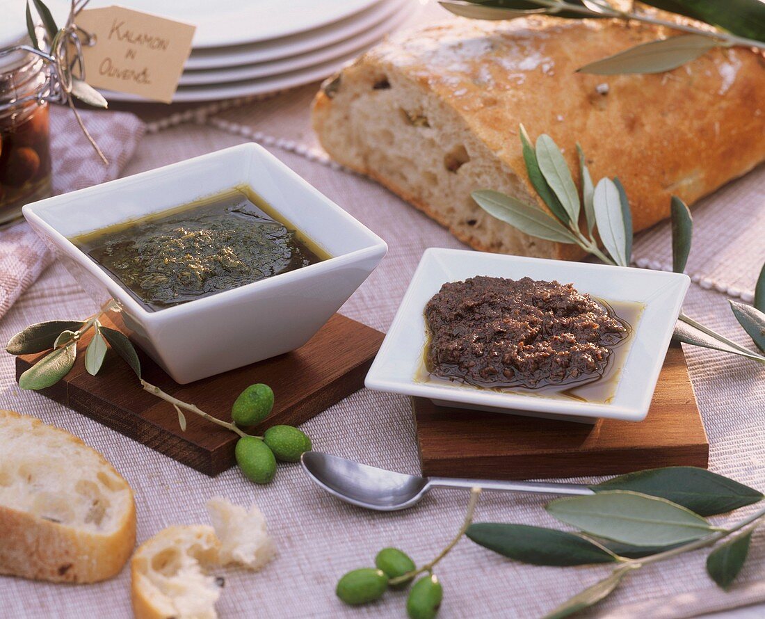 Basilikum- und Tomatenpesto in Schälchen mit Oliven, Ciabatta