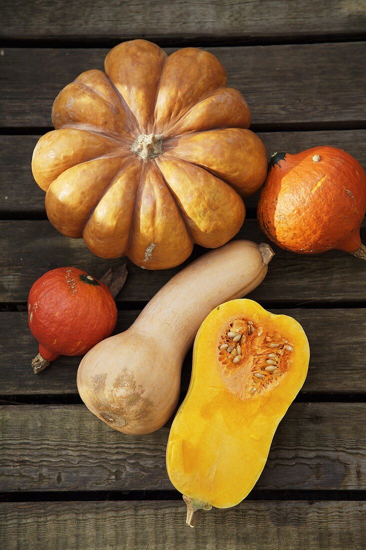 Pumpkin, butternut- & Hokkaido squashes on wooden background