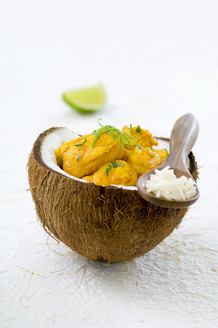 Curry-Seeteufel mit Kokos in einer Kokosnusshälfte