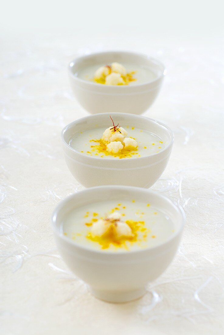 Three bowls of cauliflower soup with saffron