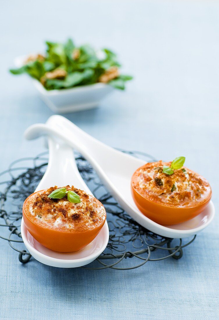 Baked, stuffed tomatoes on china spoons