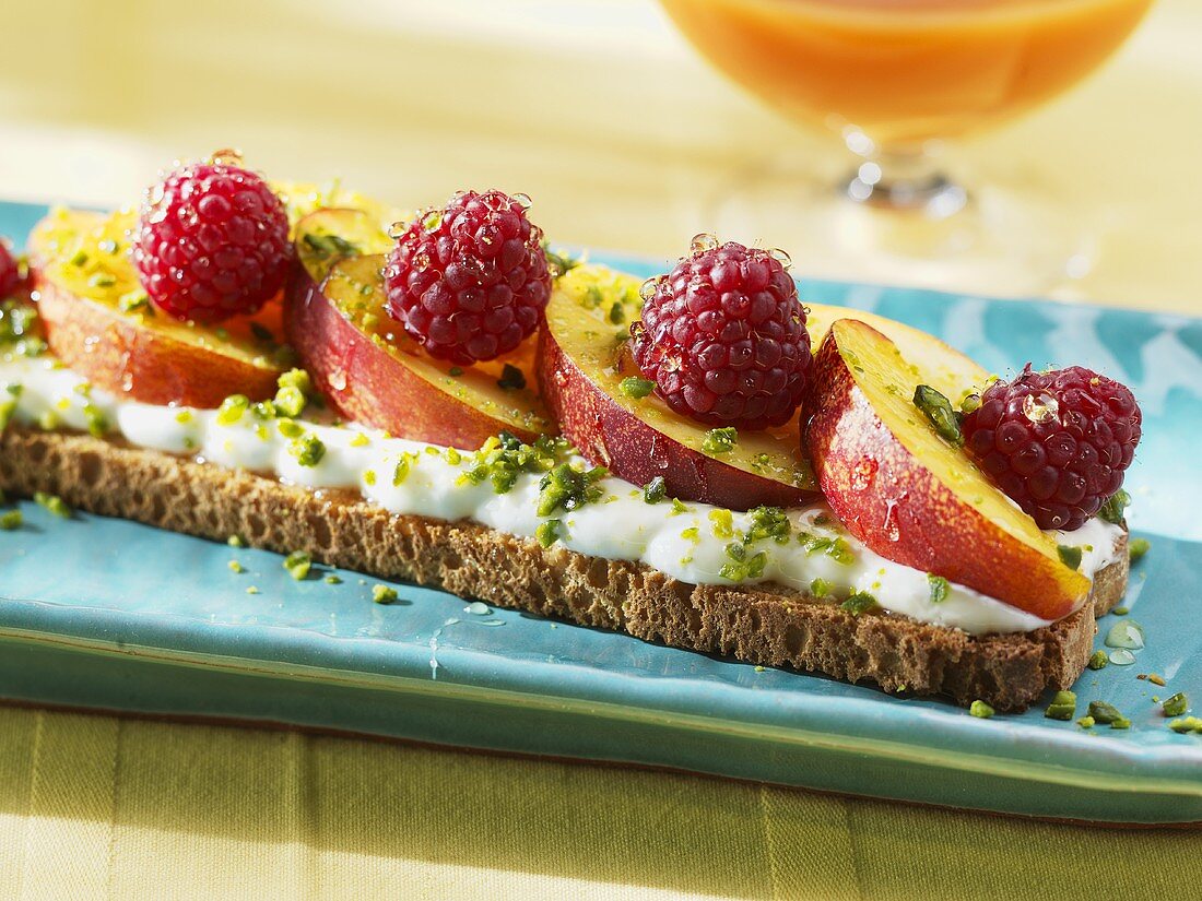 Getoastetes Brot mit Joghurt, Pfirsich, Himbeeren und Honig