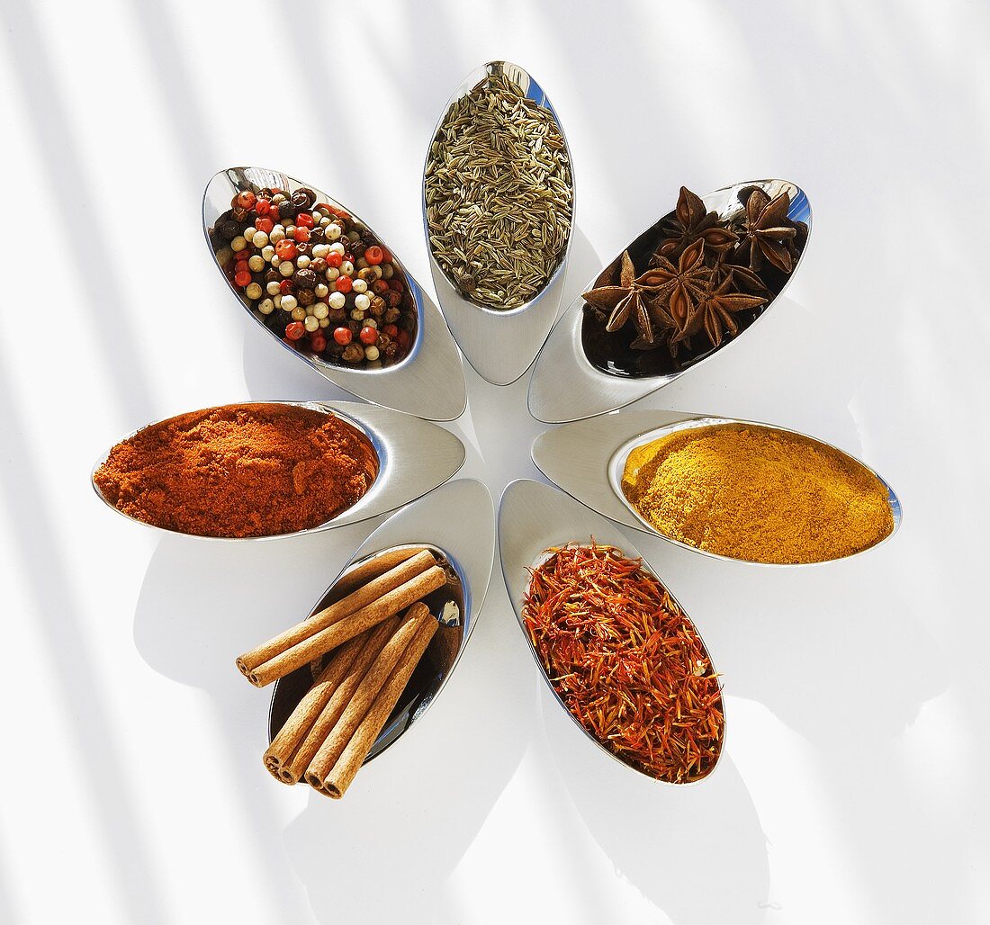 Seven different spices in small metal dishes