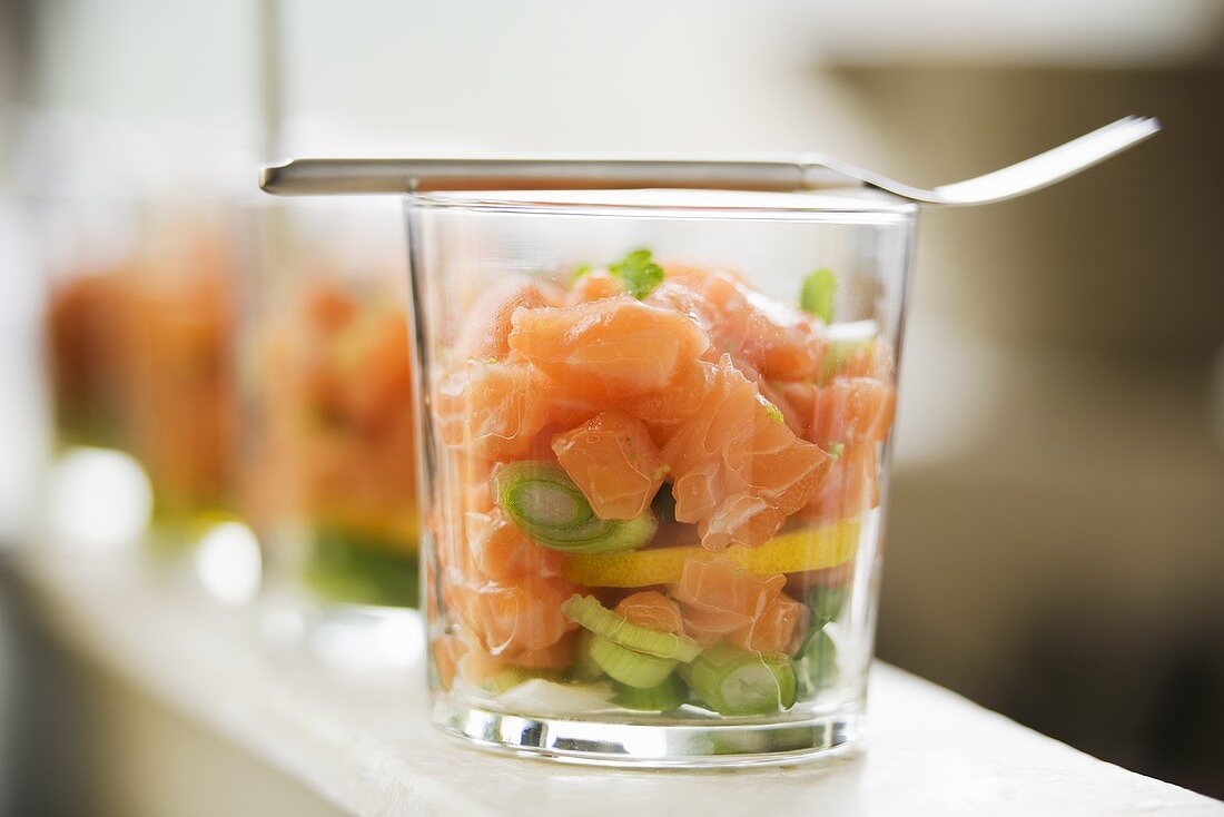 Salmon tartare with coriander on spring onions in glasses