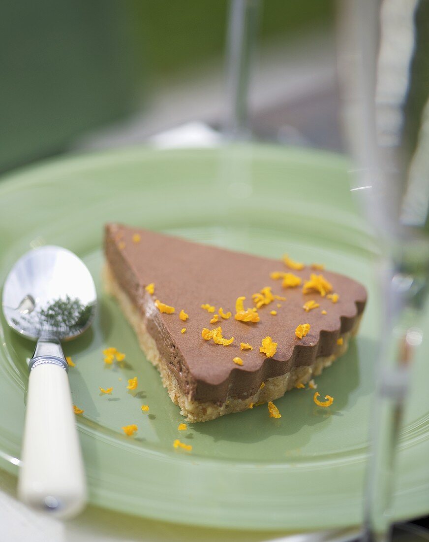 A piece of orange chocolate cheesecake with biscuit base