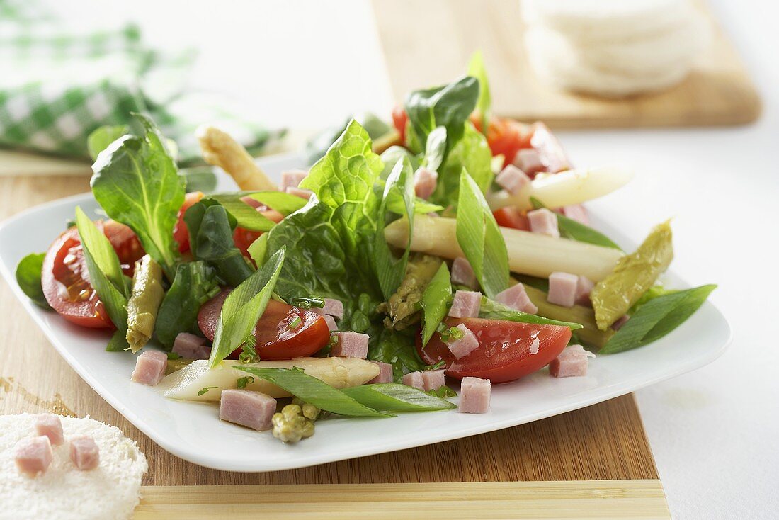 Salad leaves with asparagus, ham and tomato