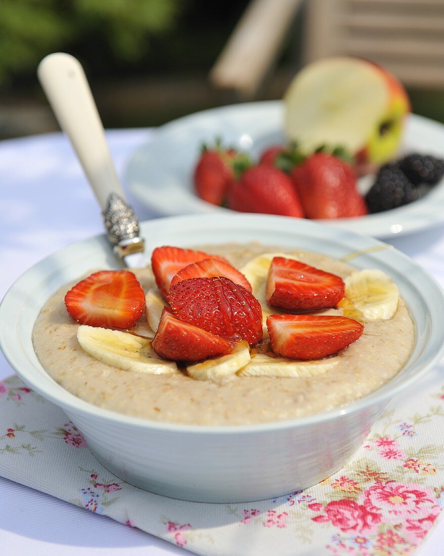 Zimt-Porridge mit frischen Erdbeeren und Banane in Schüssel