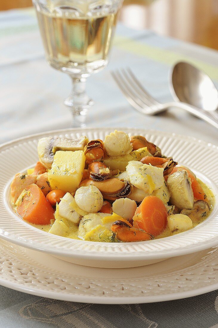 Meeresfrüchte-Ragout mit einem Glas Weißwein