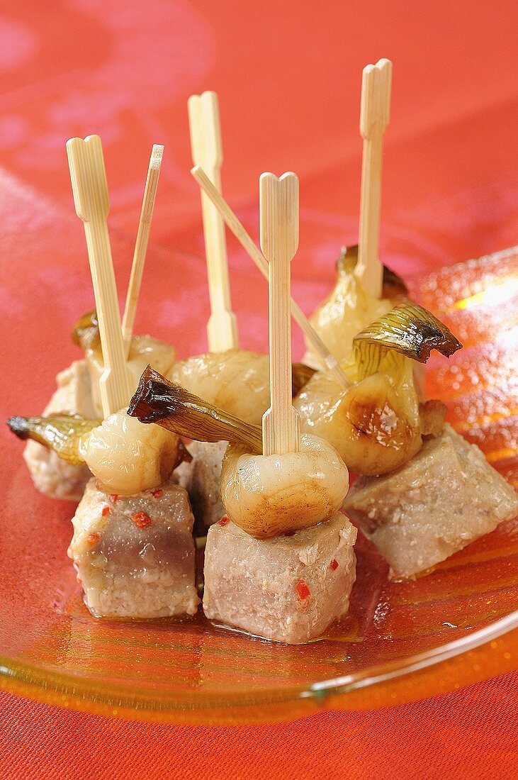 Marinated tuna and spring onions on sticks