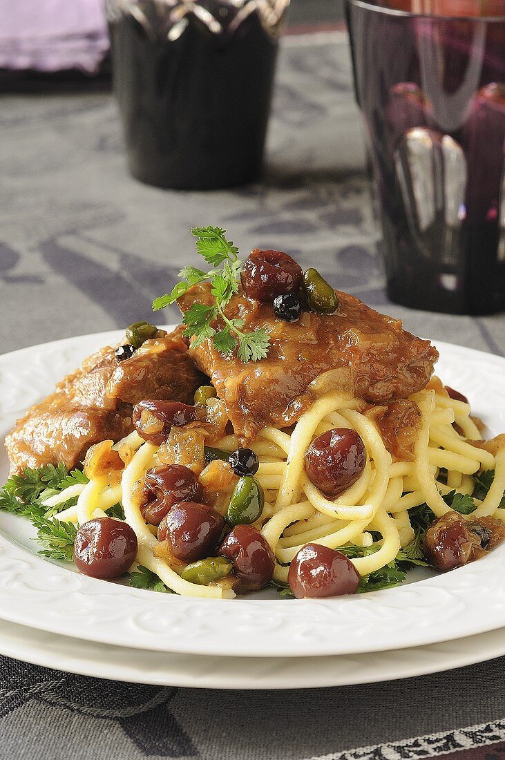 Braised veal with sour cherries and pistachios on noodles