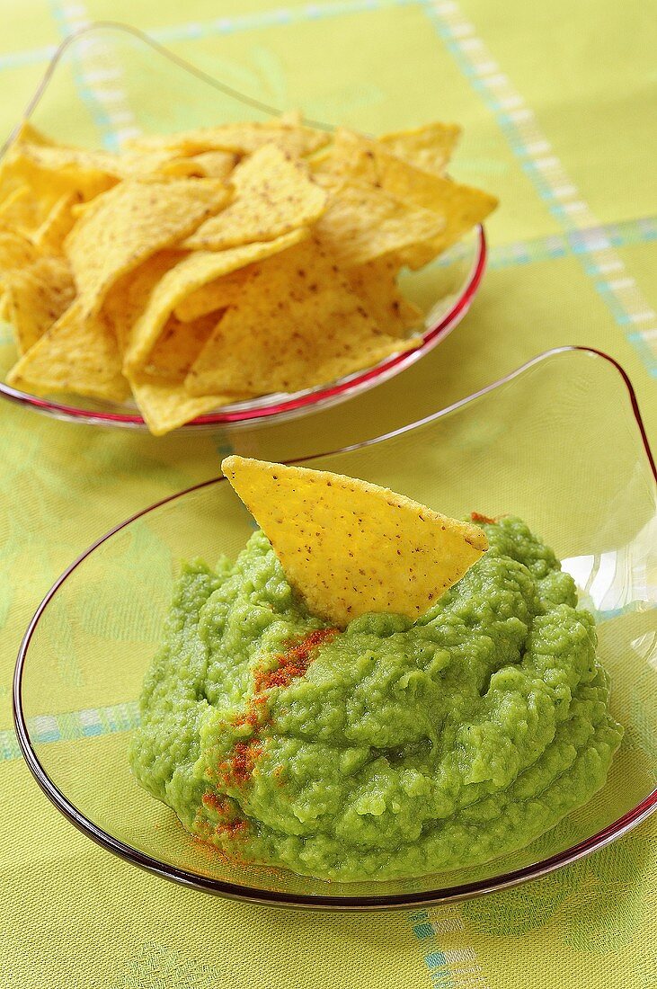 Broccoli dip with tortilla chips in glass dishes