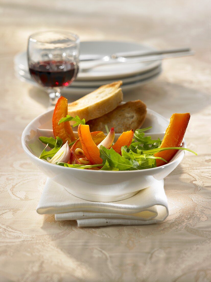 Eine Schale Kürbis-Rucola-Salat mit Honigdressing