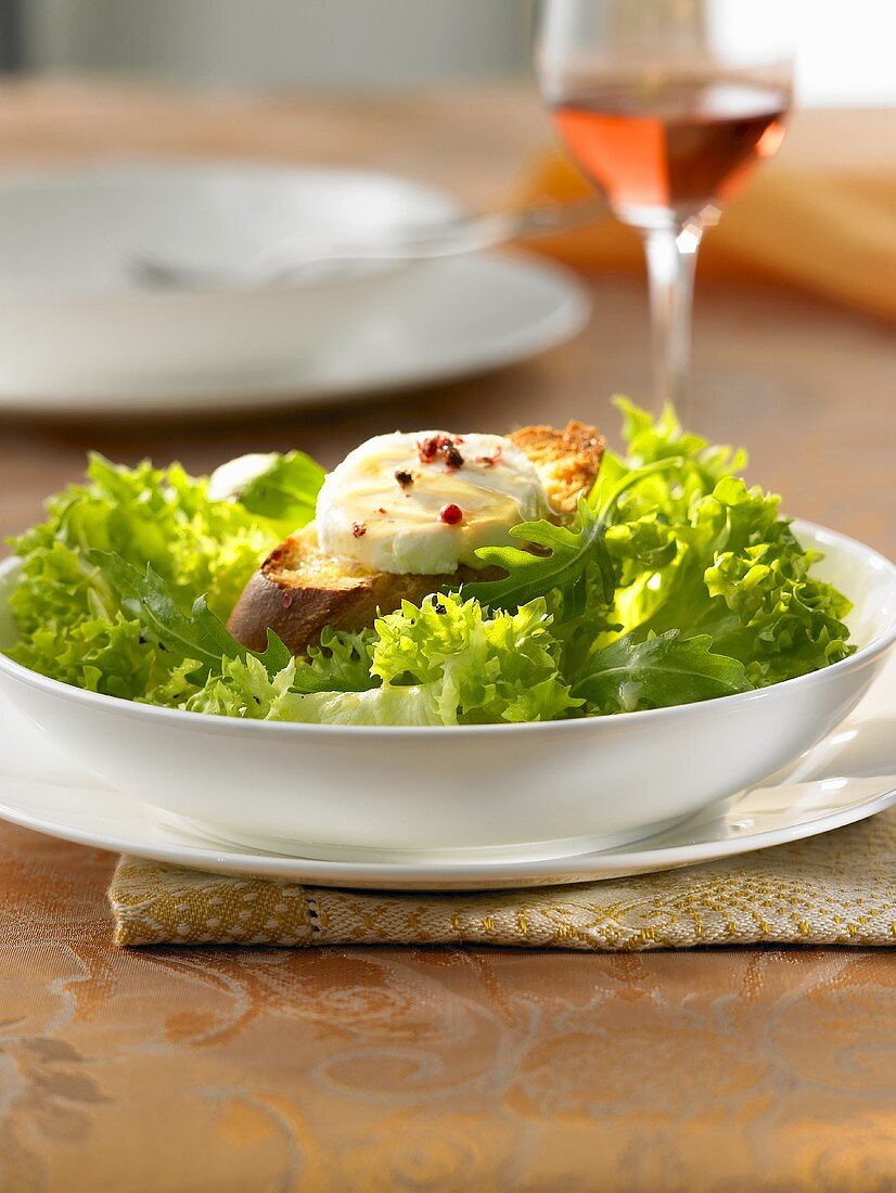 Überbackener Ziegenkäse mit Baguette auf Blattsalat