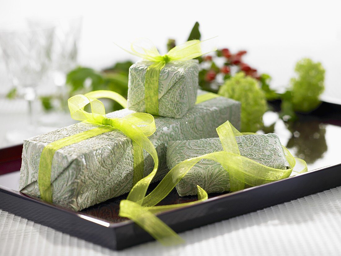 Christmas gifts wrapped in green paper with green ribbons