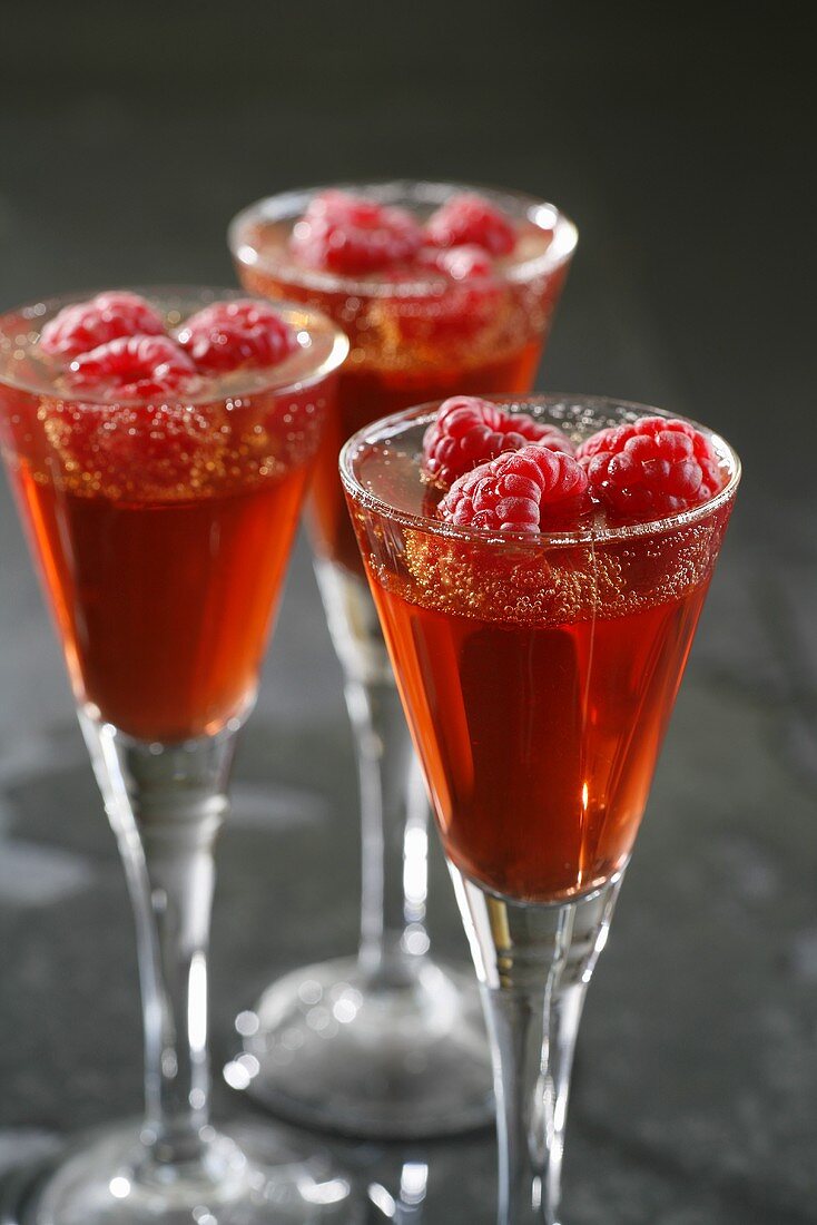 Kir Royal jelly with fresh raspberries in three glasses