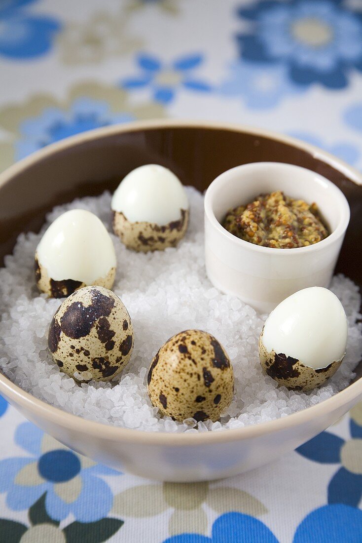 Unshelled and half-shelled quails' eggs on sea salt