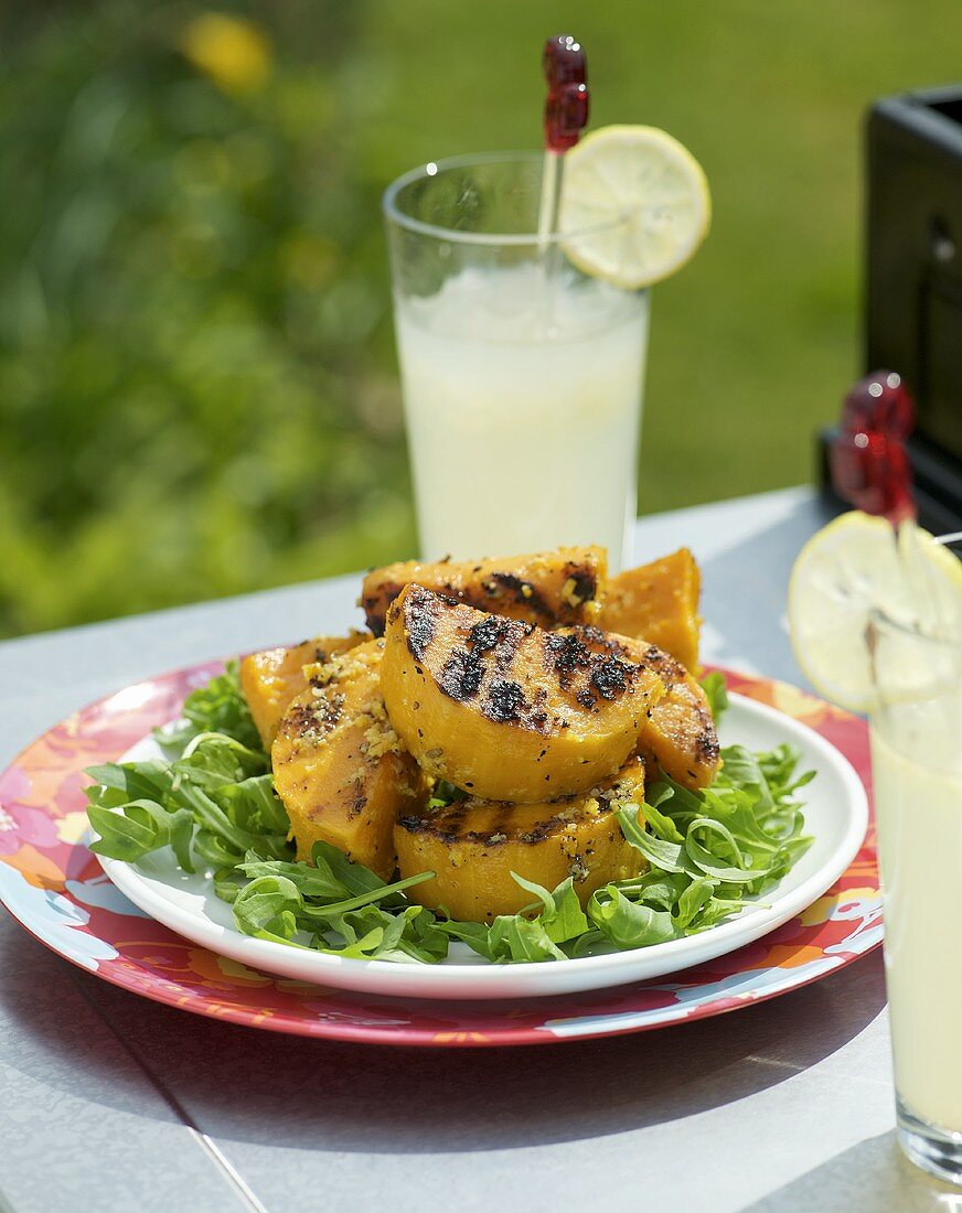 Gegrillter Kürbis auf Rucola im Freien