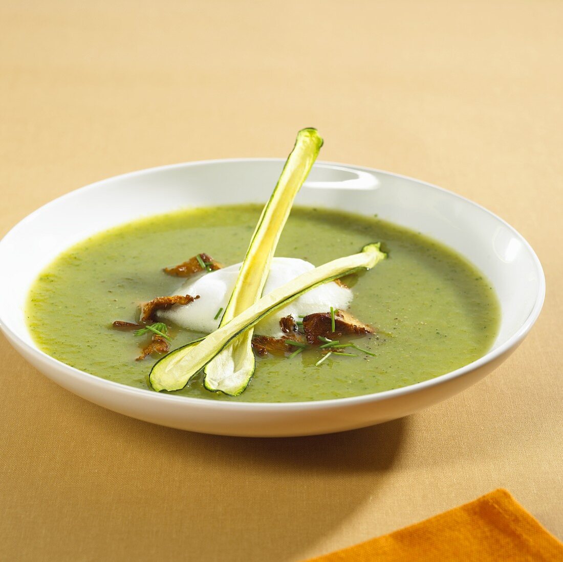 A plate of courgette and pepper soup with chanterelles