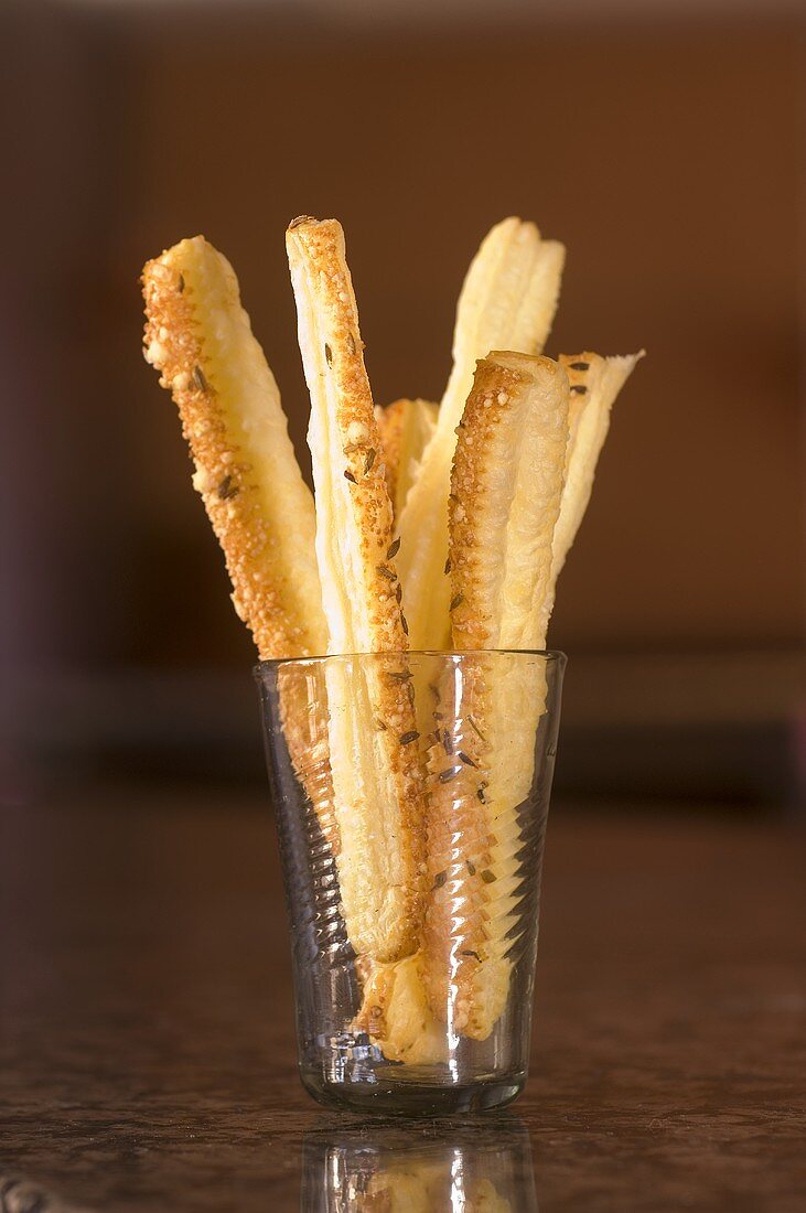 Puff pastry straws with Parmesan and cumin in a glass