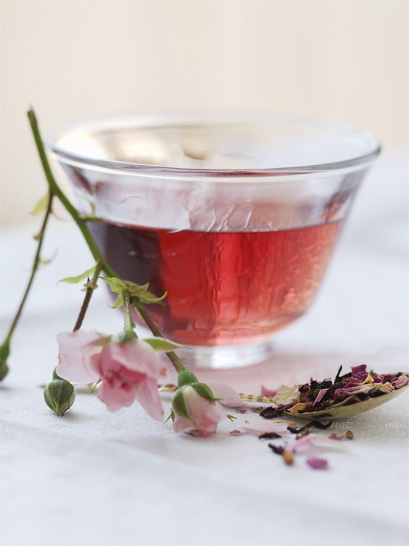 A bowl of rose tea with dried and fresh flowers