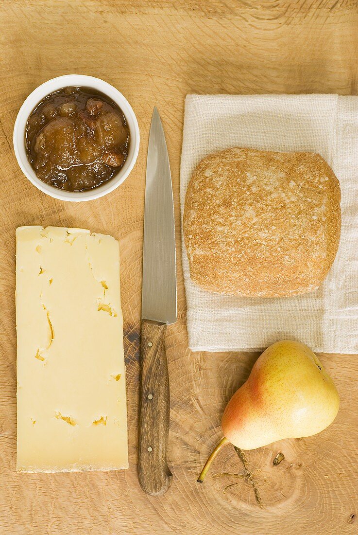 Cheddar cheese, apple chutney, bread and a pear