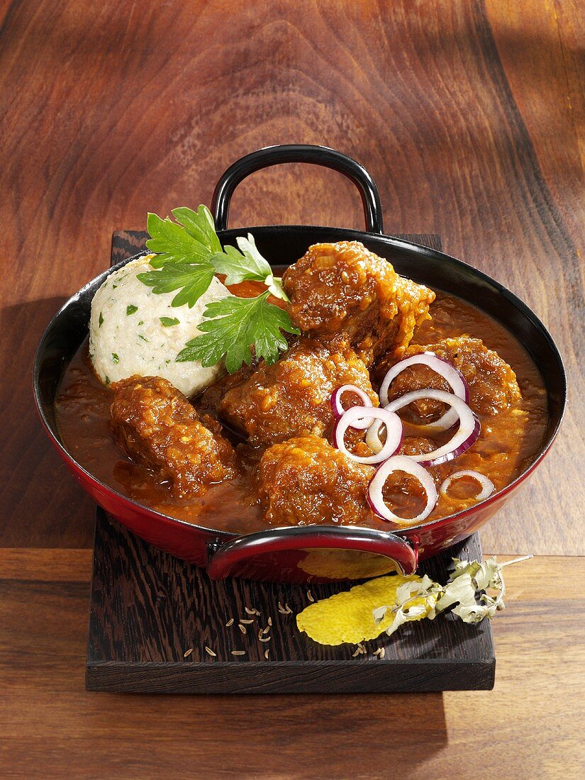 Rindergulasch mit Semmelknödel in einer Pfanne