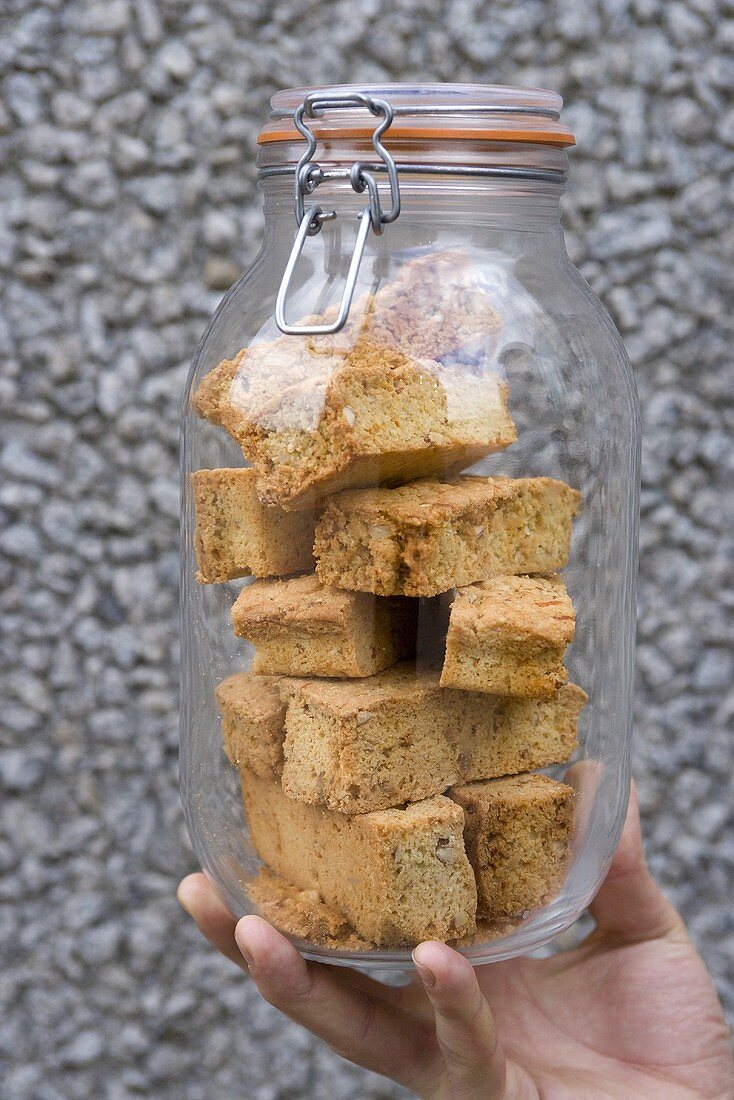 Hand holding a preserving jar containing biscotti