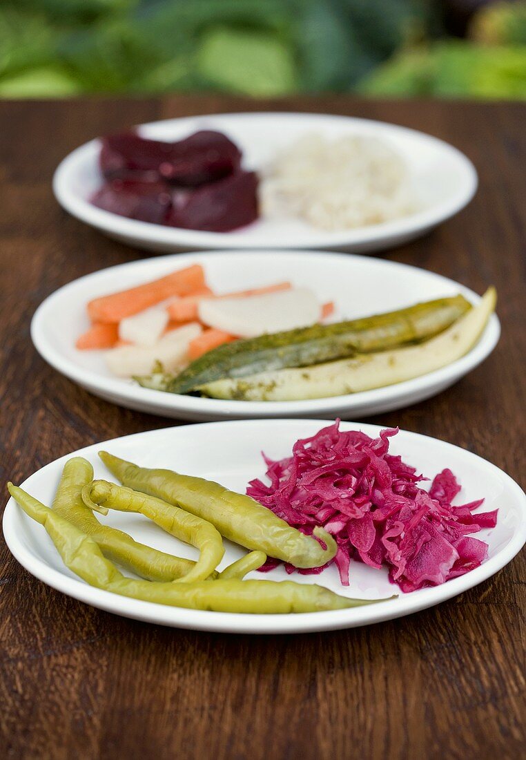 A selection of pickled vegetables on three platters