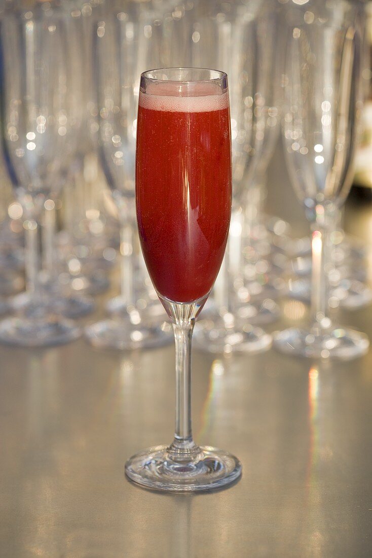 A glass of sparkling wine with strawberry puree