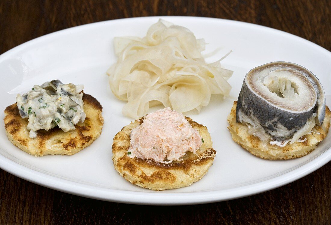 Blinis mit Räucherlachs, Hering, Meerrettich und Fenchel