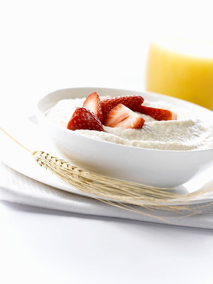 Porridge mit frischen Erdbeeren und einem Glas Orangensaft