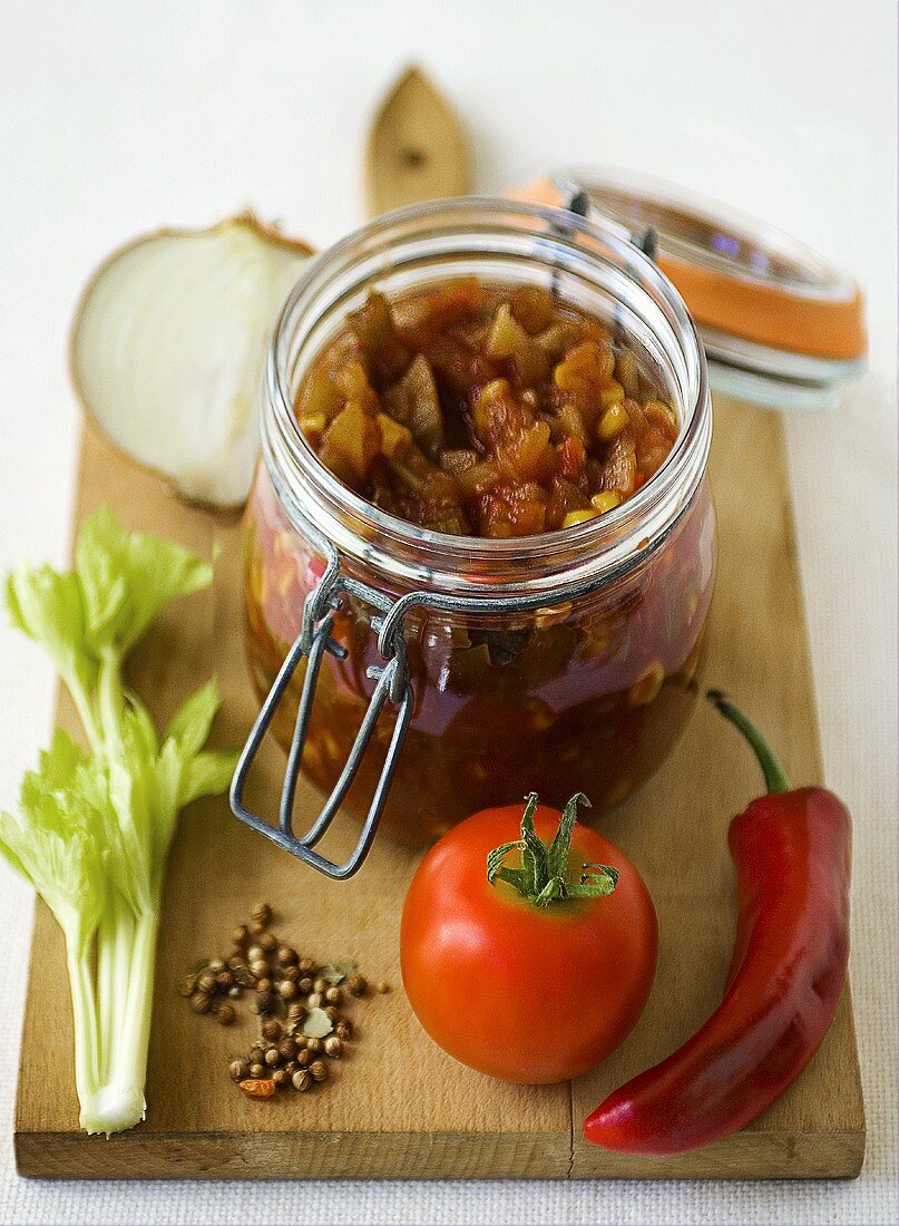 Tomato relish in a preserving jar with ingredients