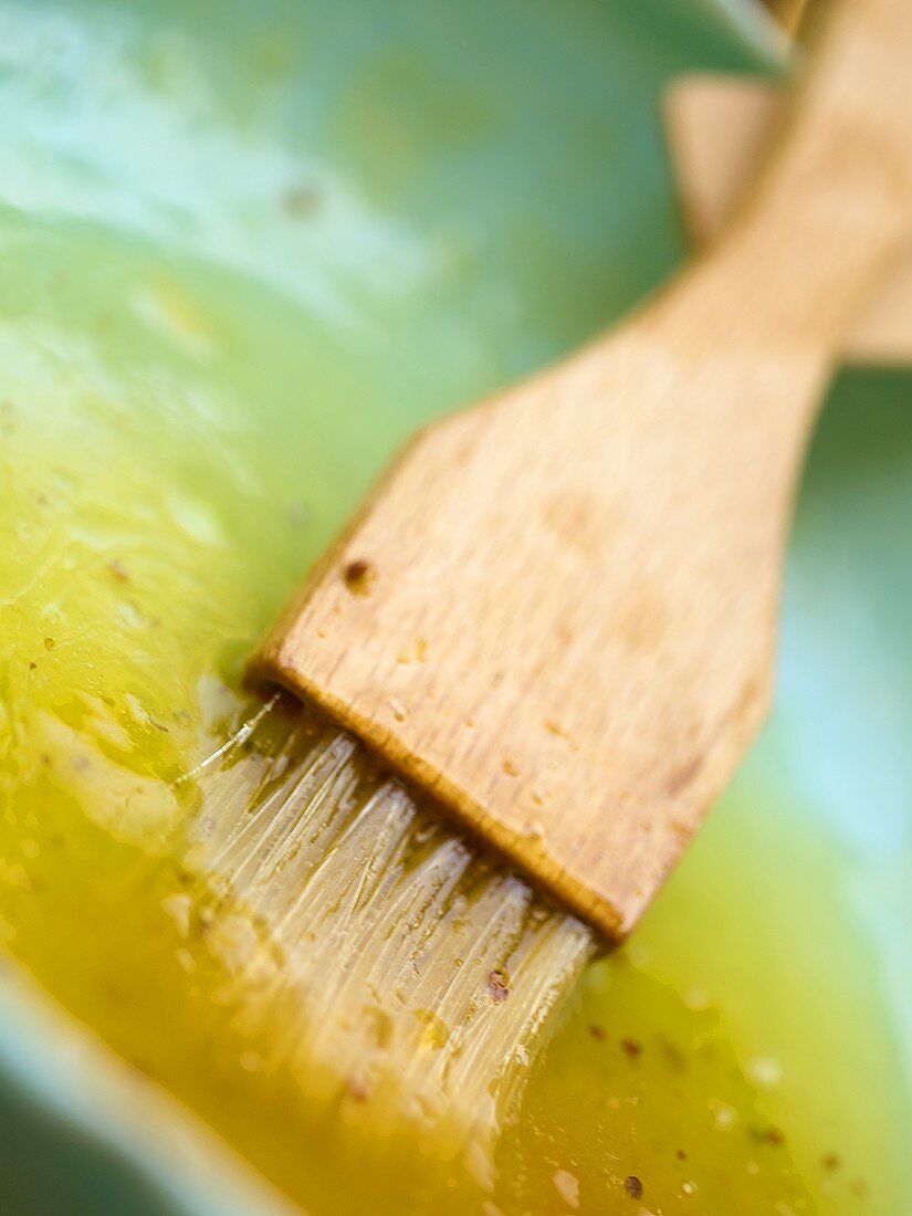 Marinade mit einem Pinsel in einem Schälchen