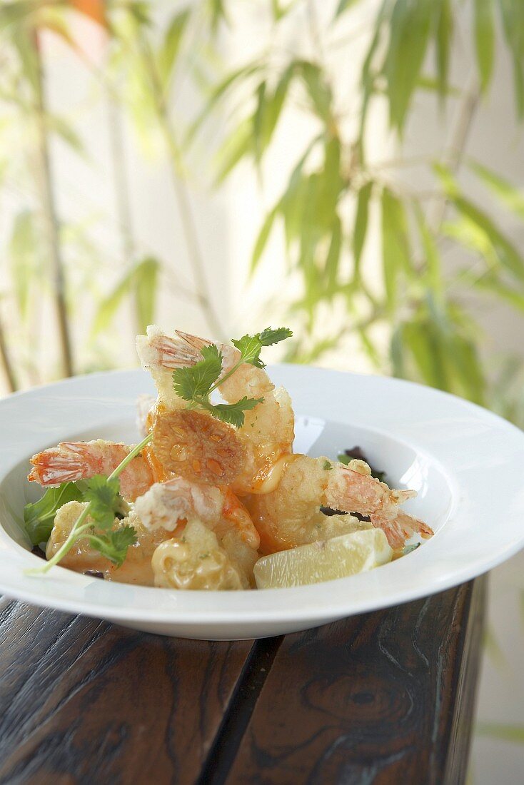 Deep-fried prawns in tempura batter on salad leaves