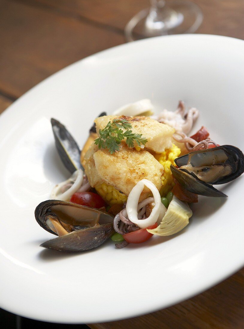 Fried halibut on saffron risotto and seafood