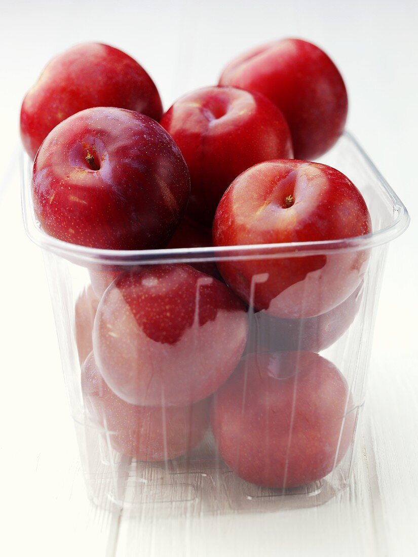 Red plums in a plastic punnet
