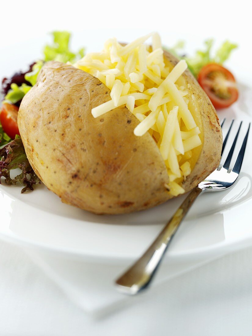 Ofenkartoffel mit geriebenem Käse und Salat