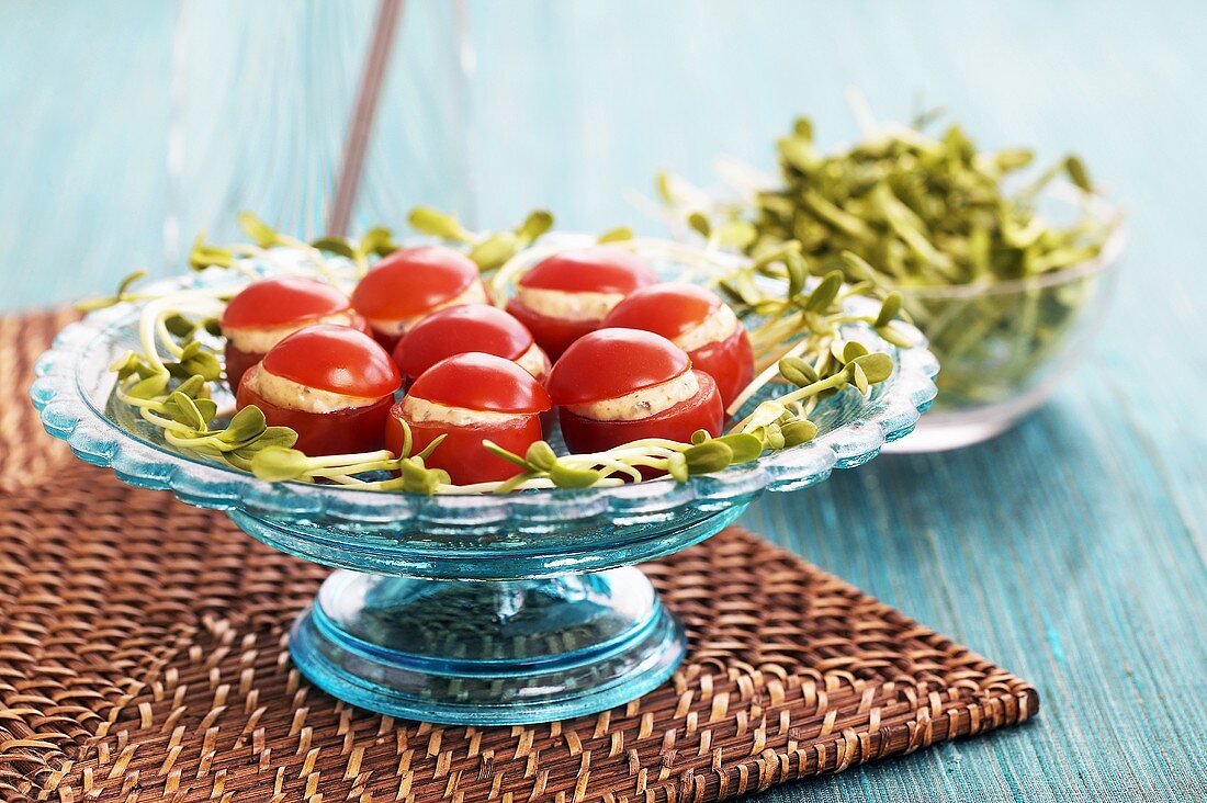 Tomatoes stuffed with cheese filling on a glass stand