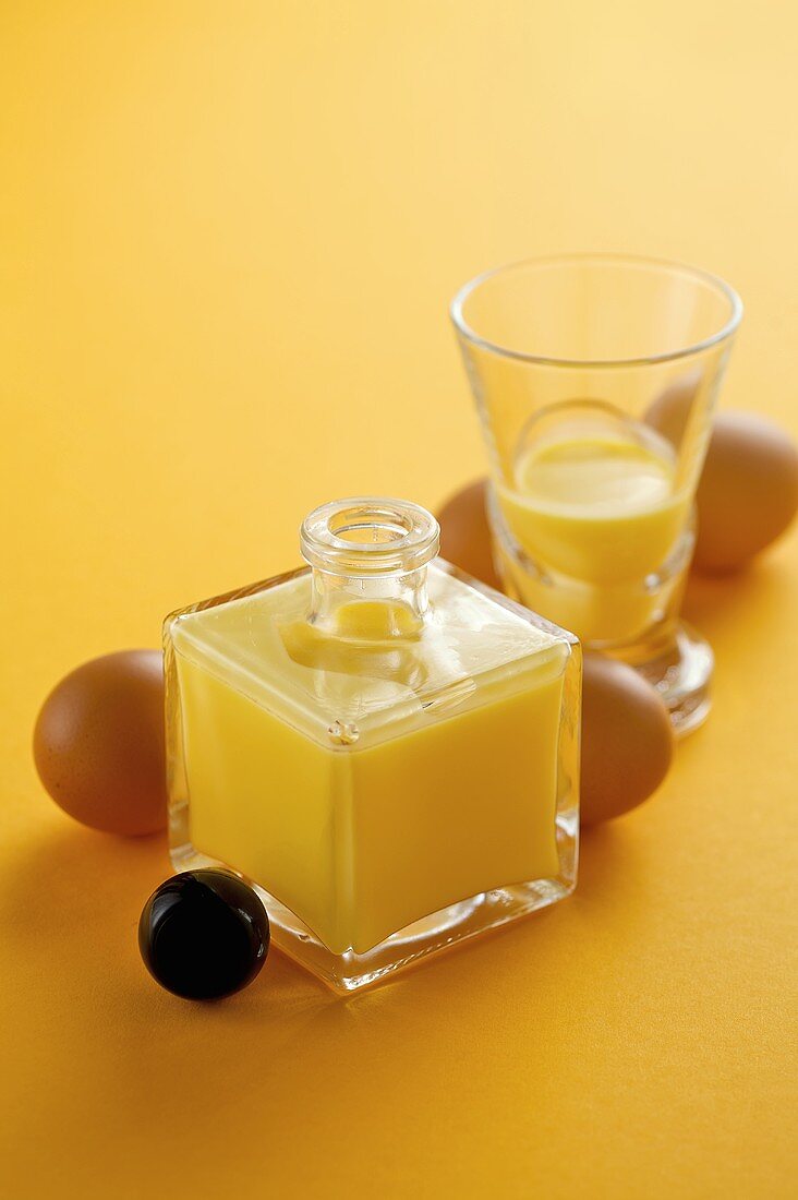 Advocaat in a bottle and a glass with fresh eggs