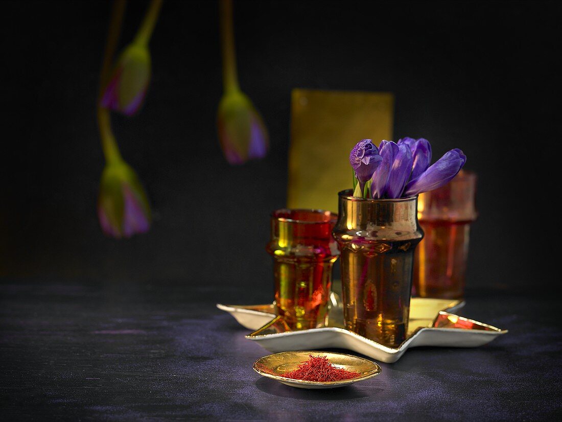 Safranfäden auf goldenem Teller mit Blumenvase