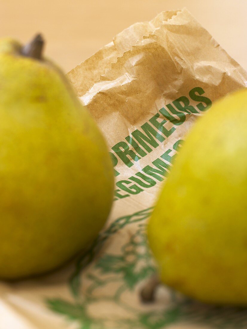 Two Williams pears on a paper bag