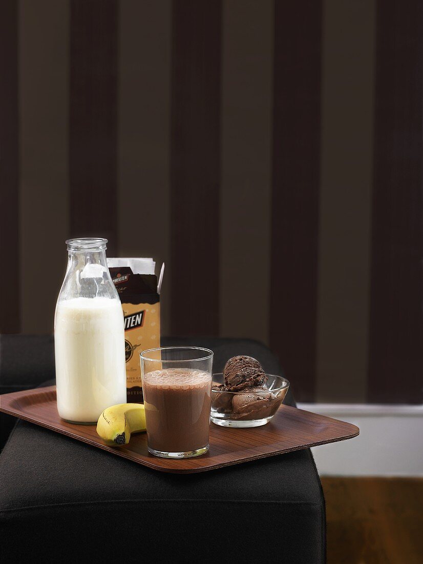 Cocoa, milk, banana and chocolate ice cream on tray