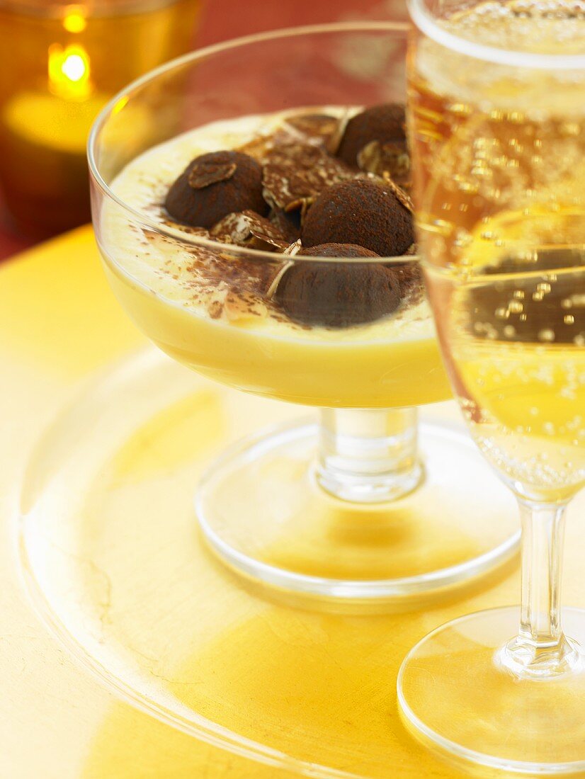 Chocolate truffles in almond cream, glass of sparkling wine