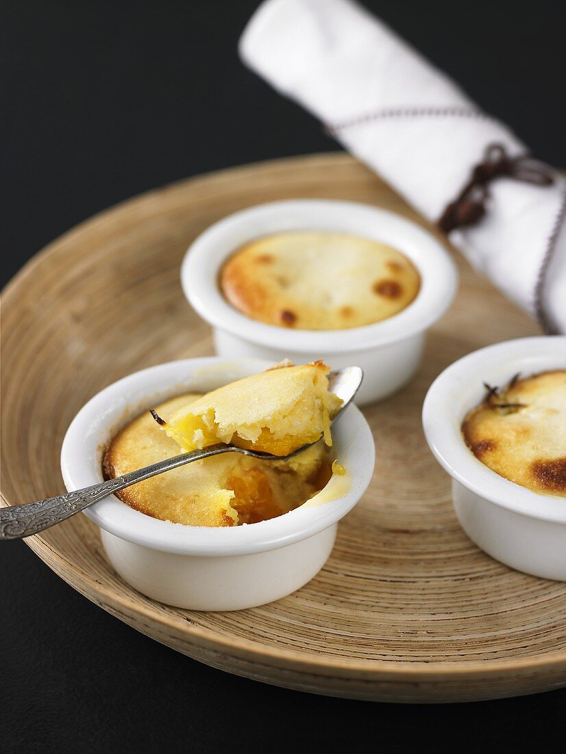 Individual peach puddings in baking dishes