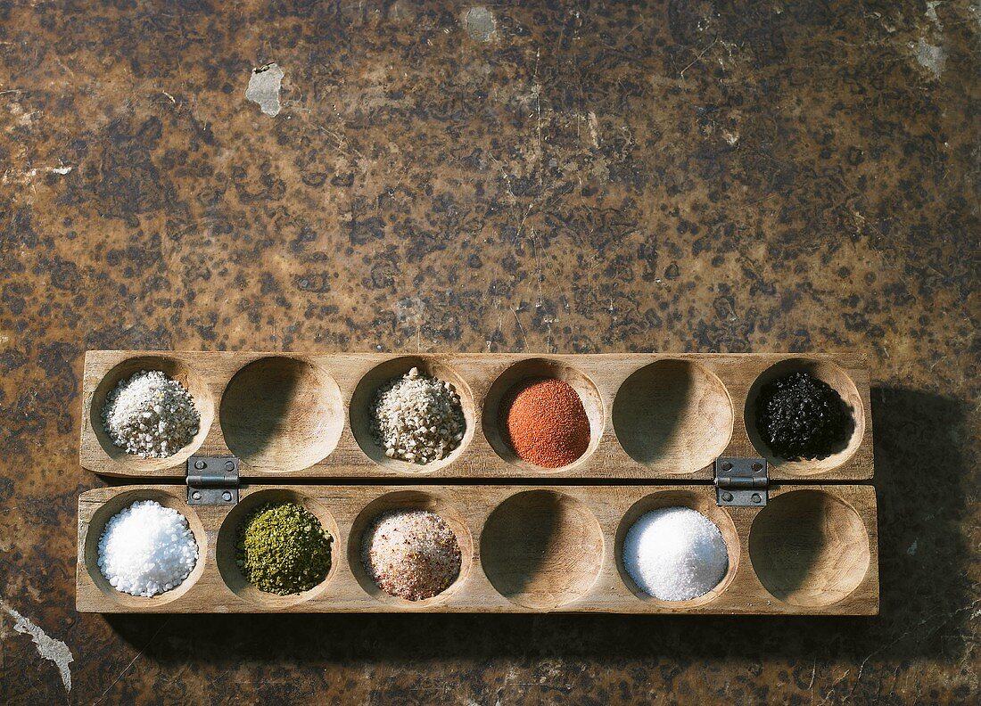 Various types of salt in a wooden game
