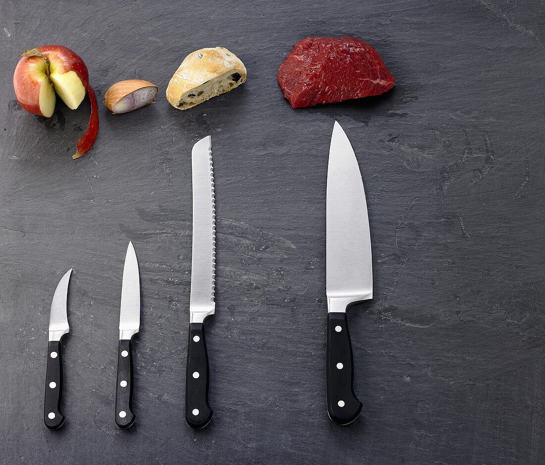Verschiedene Lebensmittel mit zugehörigen Messern