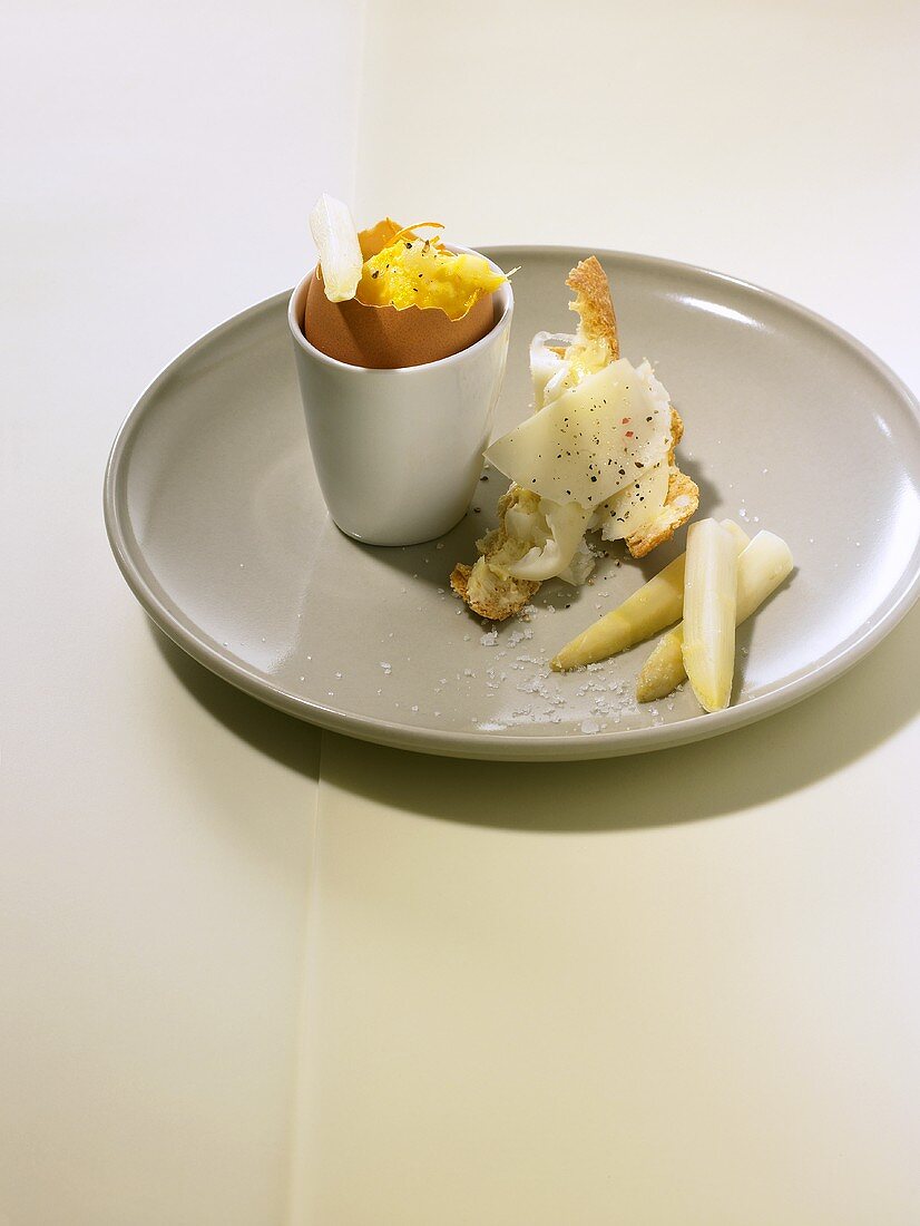 Orange scrambled egg in eggcup with asparagus & cheese baguette